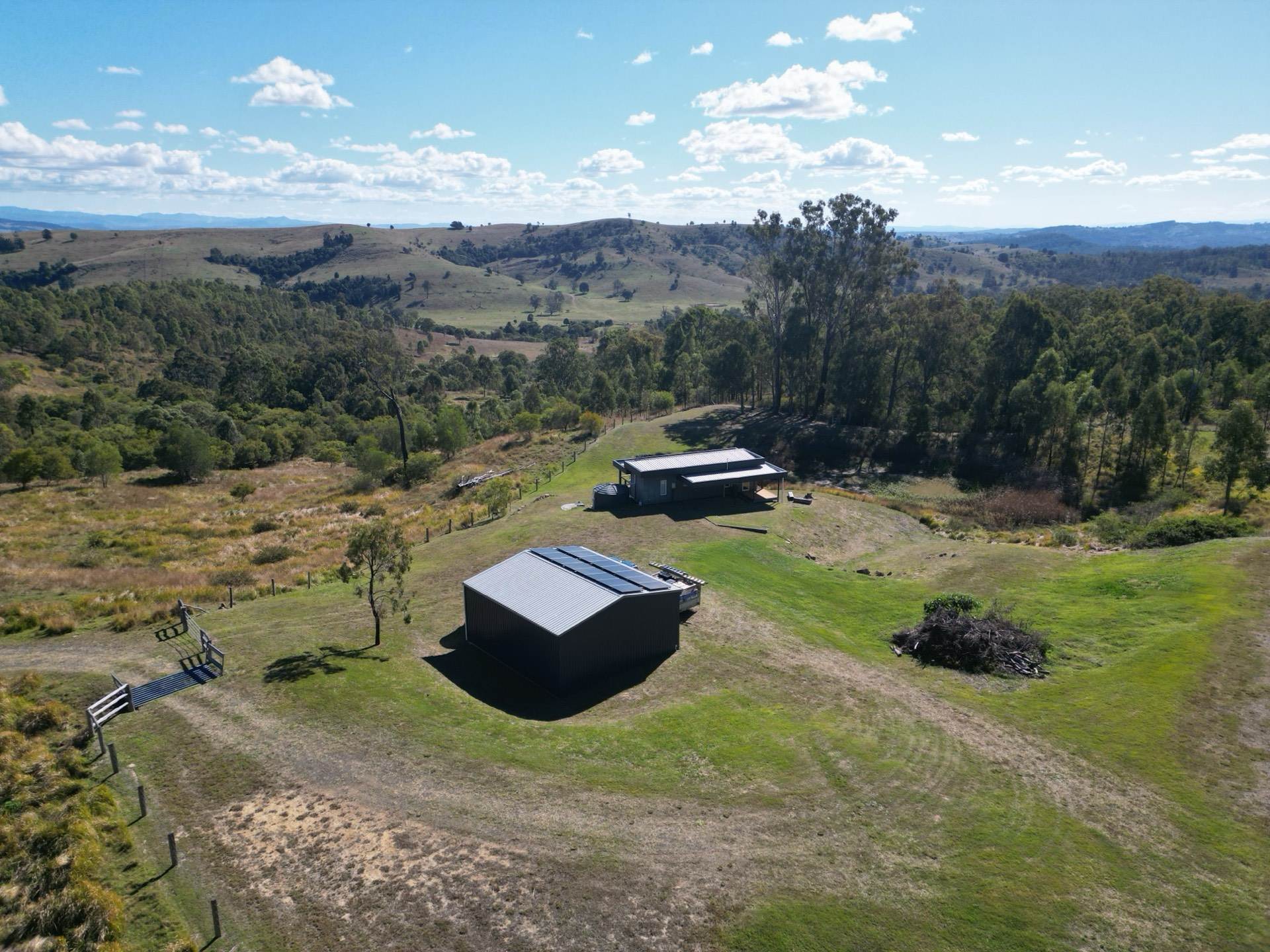 Drone view of a rural property with solar in a green valley