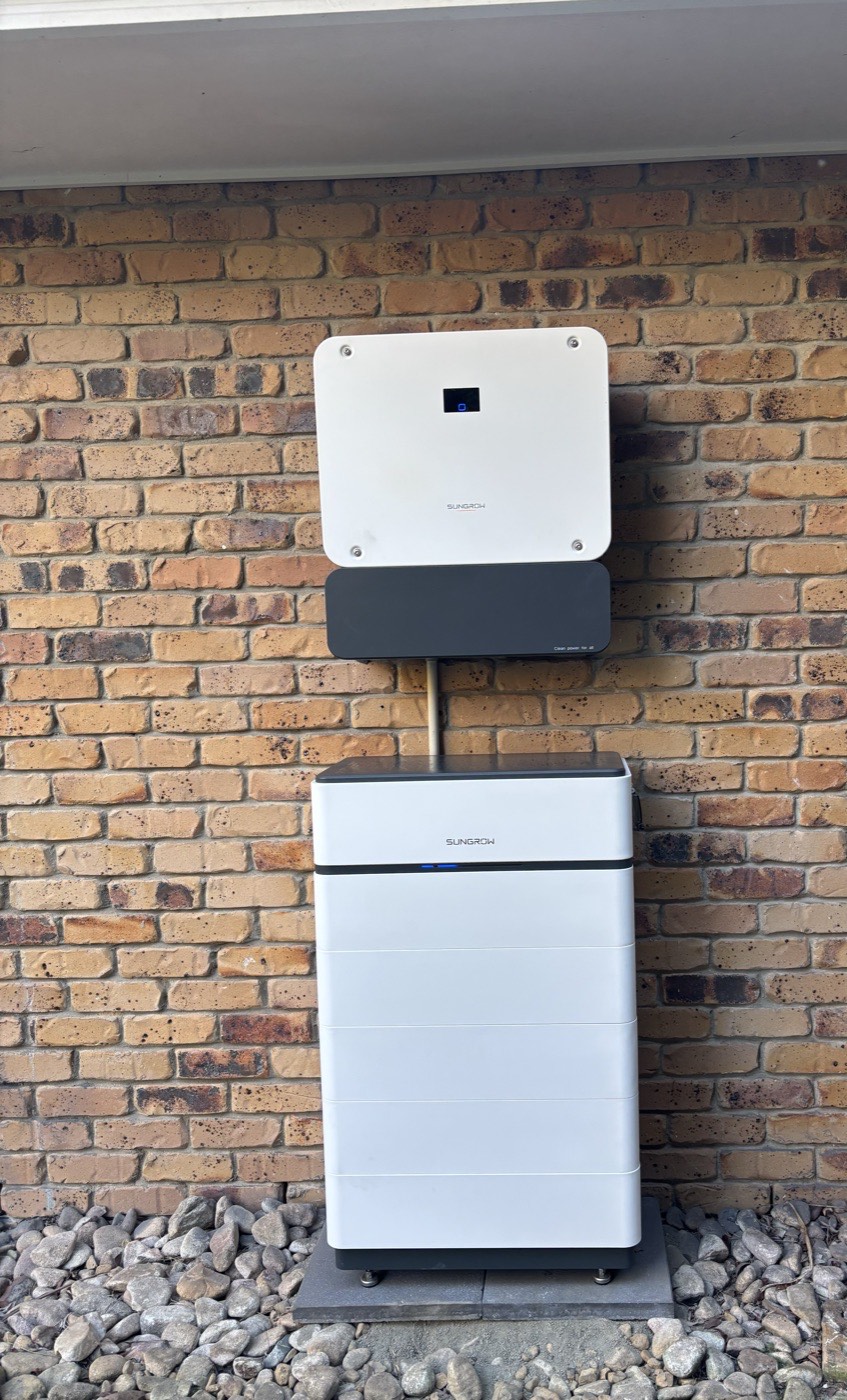 Hybrid inverter and home battery installed on a brick wall