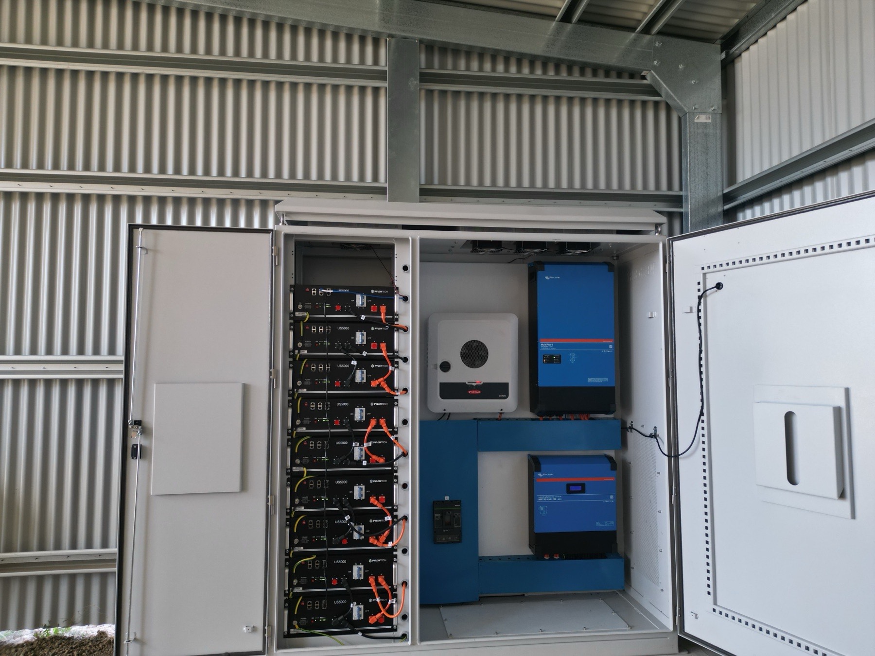 Expandable off-grid cabinet with doors open showing Victron inverter, Fronius inverter and Pylontech battery bank