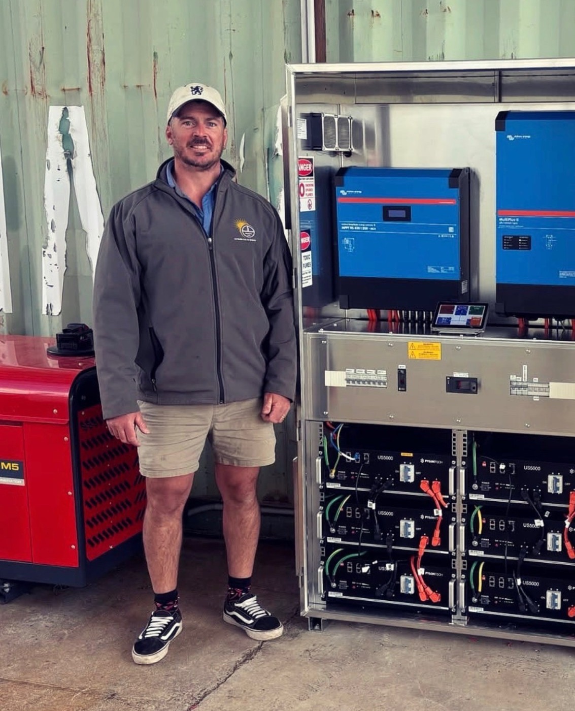 Ryan Orr, owner and installer at Optimum Solar Energy, beside a custom Victron off-grid cabinet with Pylontech batteries